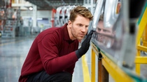 Man in production checking car doors for damage Man in production checking car doors for damage