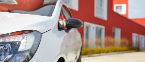 White car in front of a red building White car in front of a red building