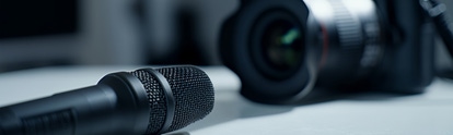 Studio microphone and blurry professional camera on a table Studio microphone and blurry professional camera on a table