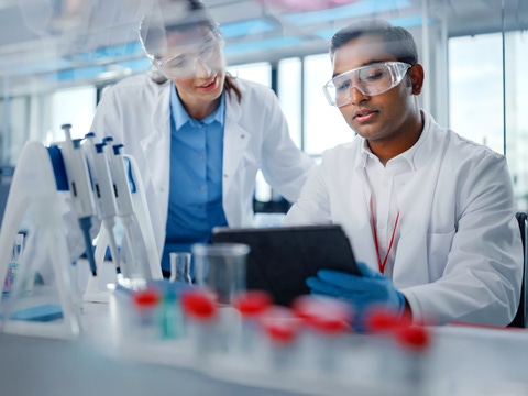 People in a lab with a tablet in their hands People in a lab with a tablet in their hands