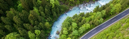 The whitewater river Steyr next to a paved road. The water is still blue from the melting snow in the montains in springtime. Location: next to the small ski resort Hinterstoder in the "Totes Gebirge" area in Upper Austria.