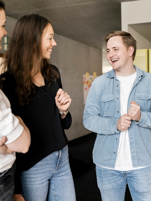 Three young DIU employees talking and laughing